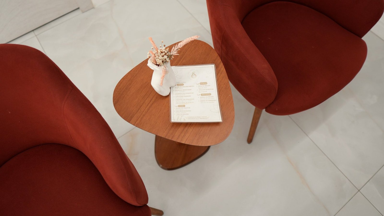 Poltronas e mesa de apoio no espaço de espera