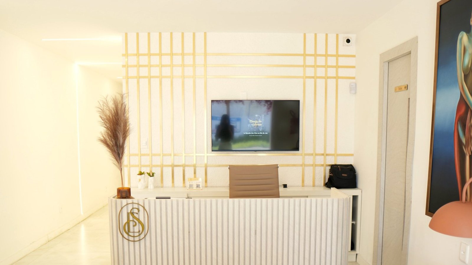 Recepção do Instituto Êmile Souza, com o balcão e o painel dourado